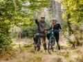 Para rowerzystów w kaskach na leśnej ścieżce. Mężczyzna wskazuje drogę, odkrywając piękną trasę w Szklarskiej Porębie.