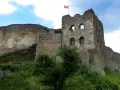 Zamek Czorsztyn, majestatyczne ruiny na wzgórzu, dumnie prezentuje polską flagę na tle błękitnego nieba.